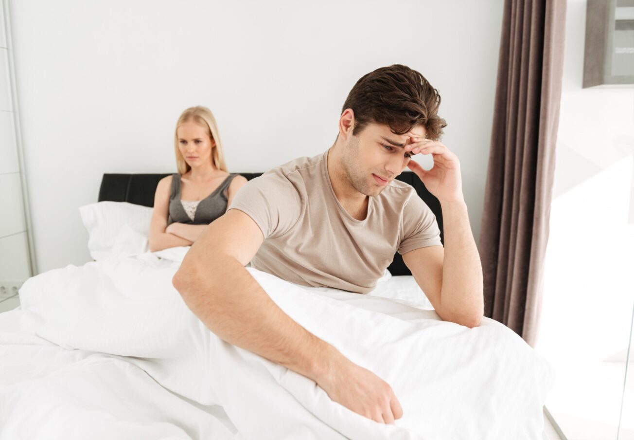 upset-man-sitting-with-his-sad-woman-bed-home_171337-4903